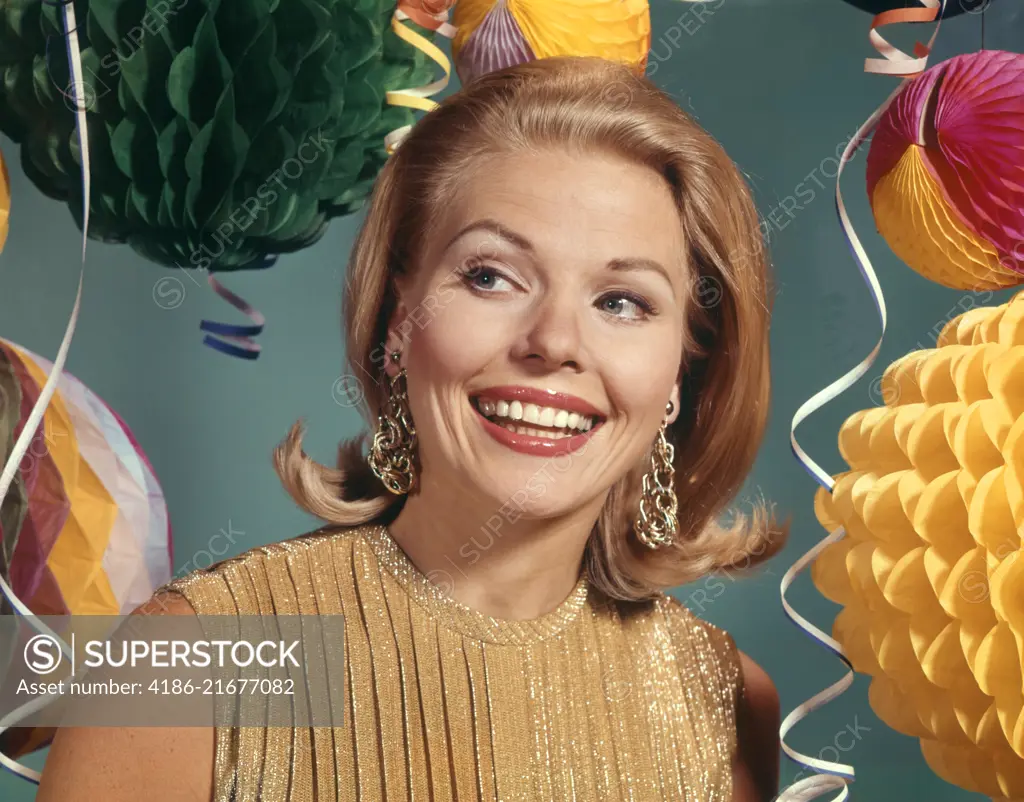 1960s SMILING BLONDE WOMAN WEARING EVENING CLOTHES GOLD LAME BLOUSE AMONG PARTY BALLOONS AND STREAMERS