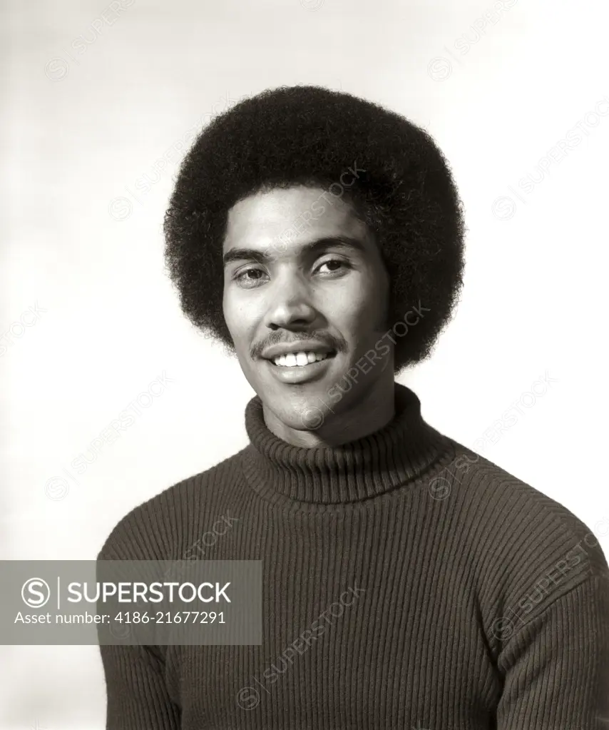 1970s 1975 SMILING AFRICAN AMERICAN MAN PORTRAIT WEARING TURTLENECK SWEATER AFRO HAIR STYLE LOOKING AT CAMERA