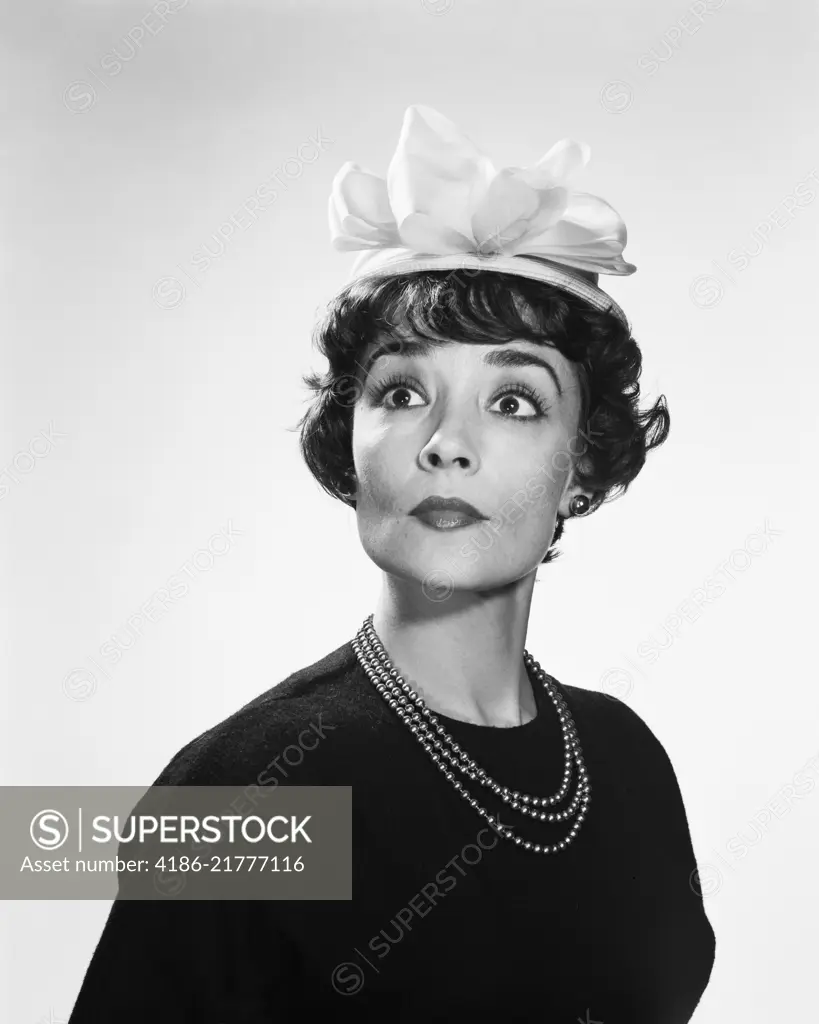 1960s BRUNETTE WOMAN WITH WIDE EYED EXPRESSION WEARING SILLY HAT hous