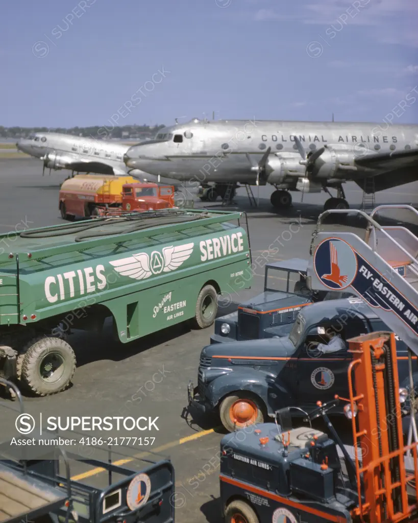 1950s COLONIAL AIRLINES AIRPLANE ON TARMAC WITH GASOLINE TRUCKS IN FOREGROUND LAGUARDIA AIRPORT NEW YORK USA