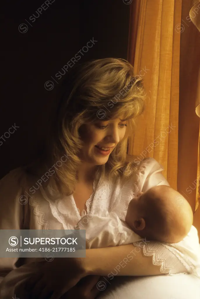 1980s 1990s WOMAN HOLDING SLEEPING BABY DAUGHTER