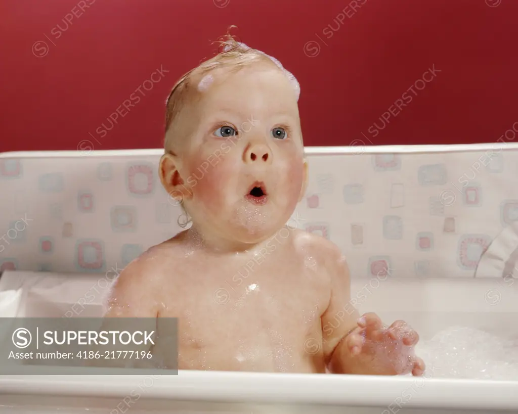 1960s EXCITED SURPRISED BABY IN BATHTUB SUDS ON HEAD AND FUNNY FACIAL EXPRESSION