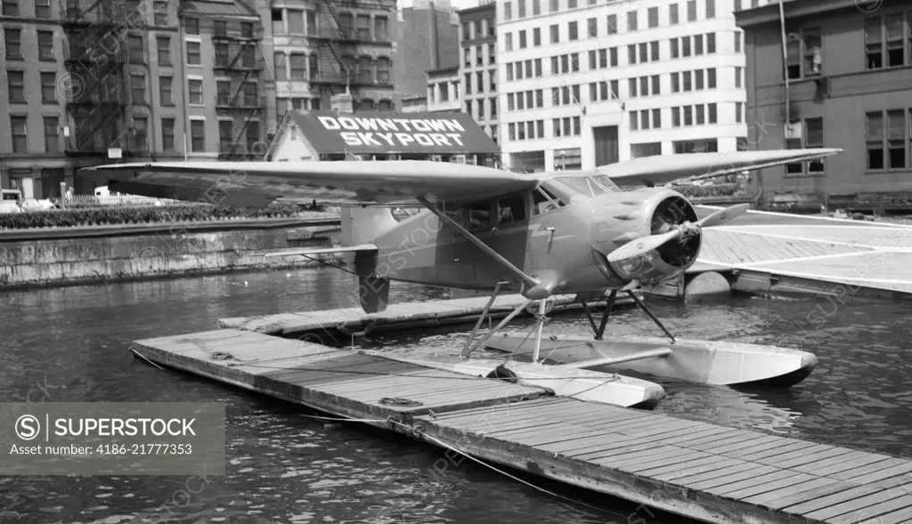 1930s 1939 WACO AIRPLANE ON FLOATS IN EAST RIVER AT WALL STREET DOWNTOWN SKYPORT NEW YORK CITY USA