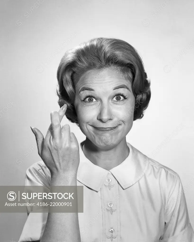 1960s WOMAN FUNNY FACIAL EXPRESSION WITH FINGERS CROSSED FOR LUCK LOOKING AT CAMERA