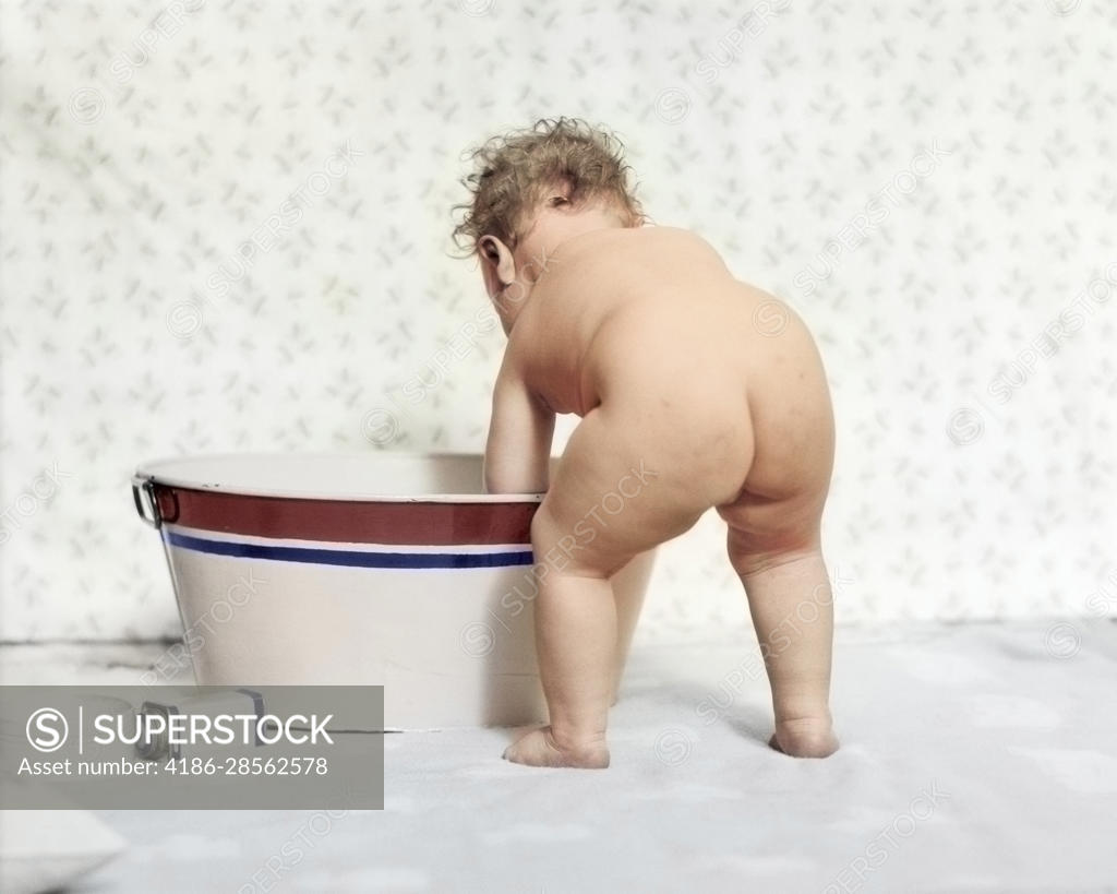 1920s 1930s NUDE BABY REAR VIEW BENDING OVER WASH TUB BATH - SuperStock