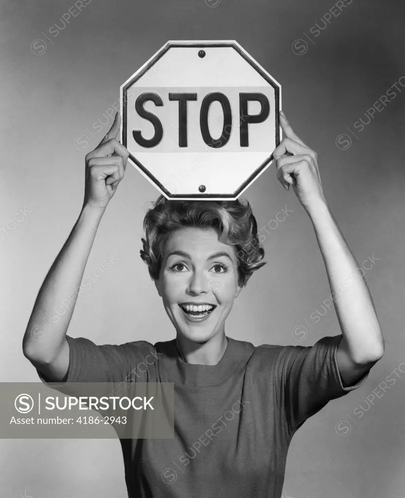 1960S Smiling Woman Holding Stop Sign Above Her Head