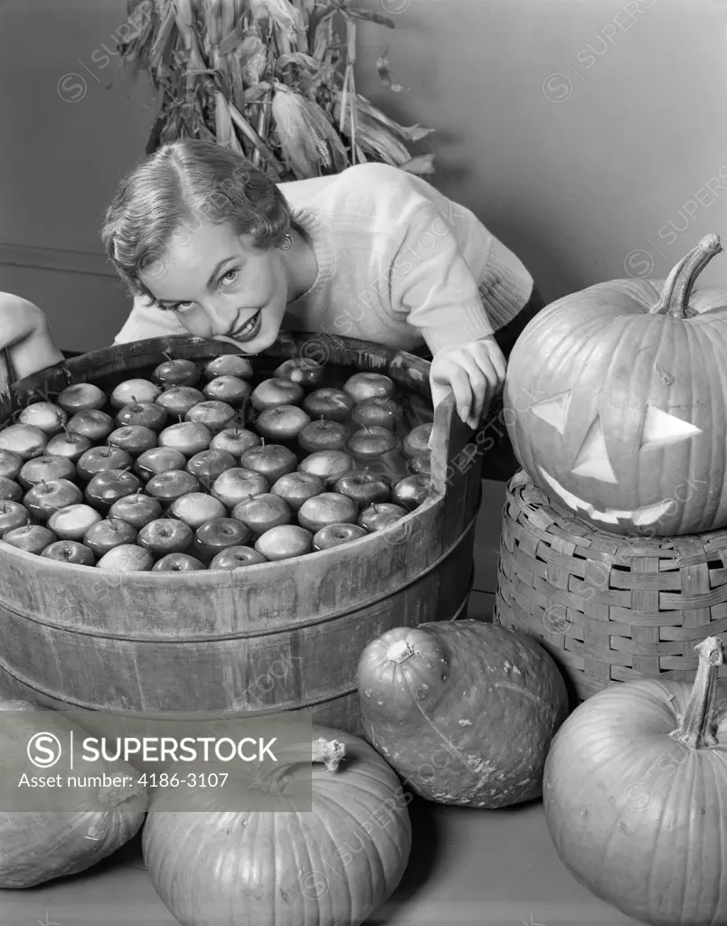 1950S Smiling Woman Leaning Over Wooden Tub Filled With Water About To Begin Bobbing For Apples