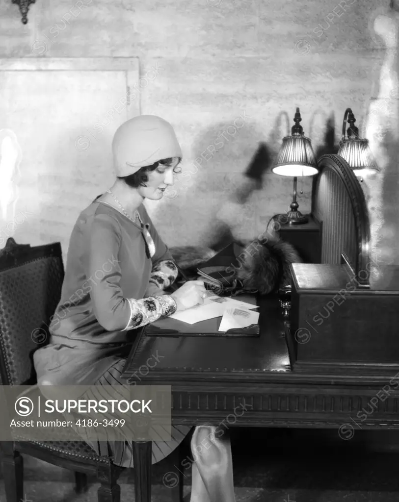 1920S Woman Sitting At Desk Writing Letter By Lamp Fashion Cloche Hat Hotel Lobby