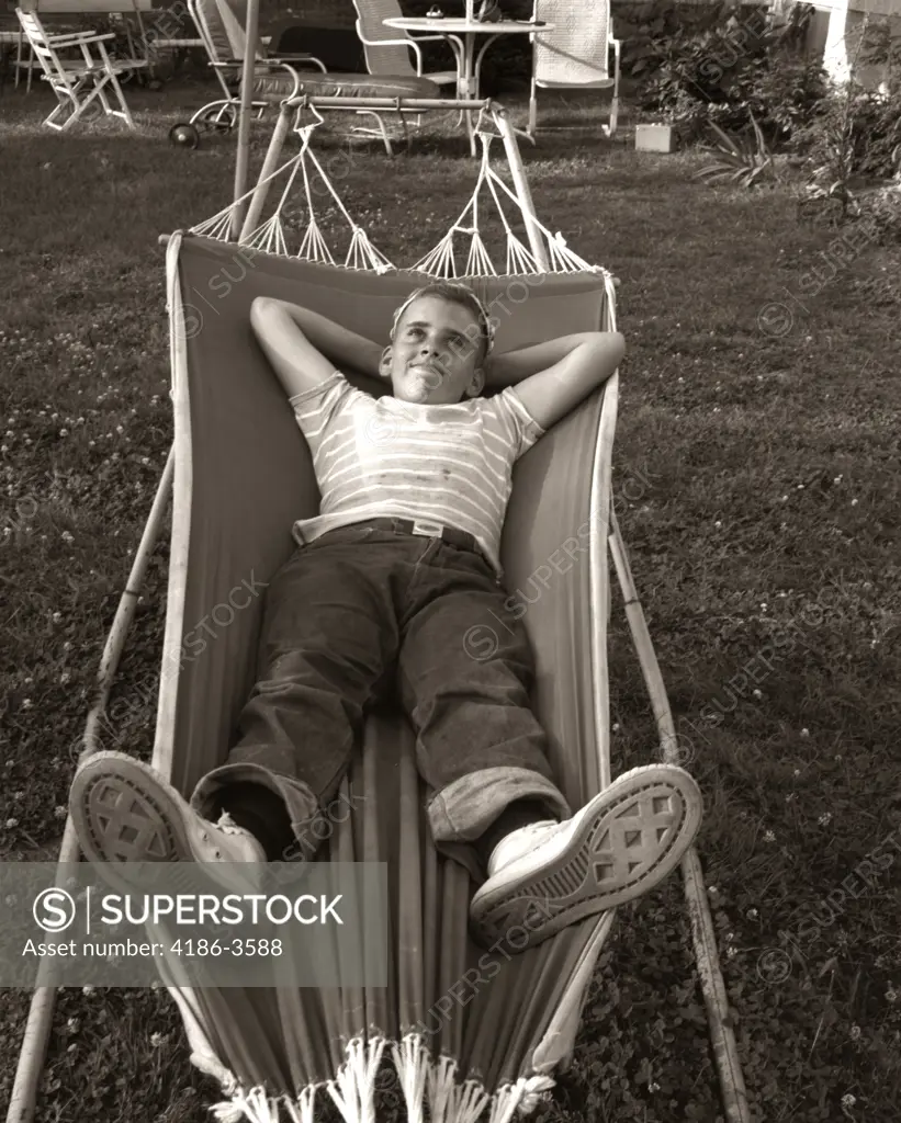 1950S Relaxed Smiling Boy Lying In Suburban Backyard Hammock