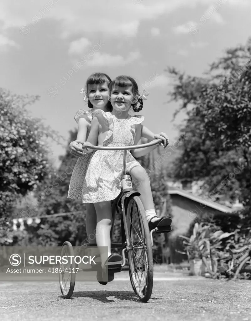 1940S Twin Girls Riding Outside On Tricycle