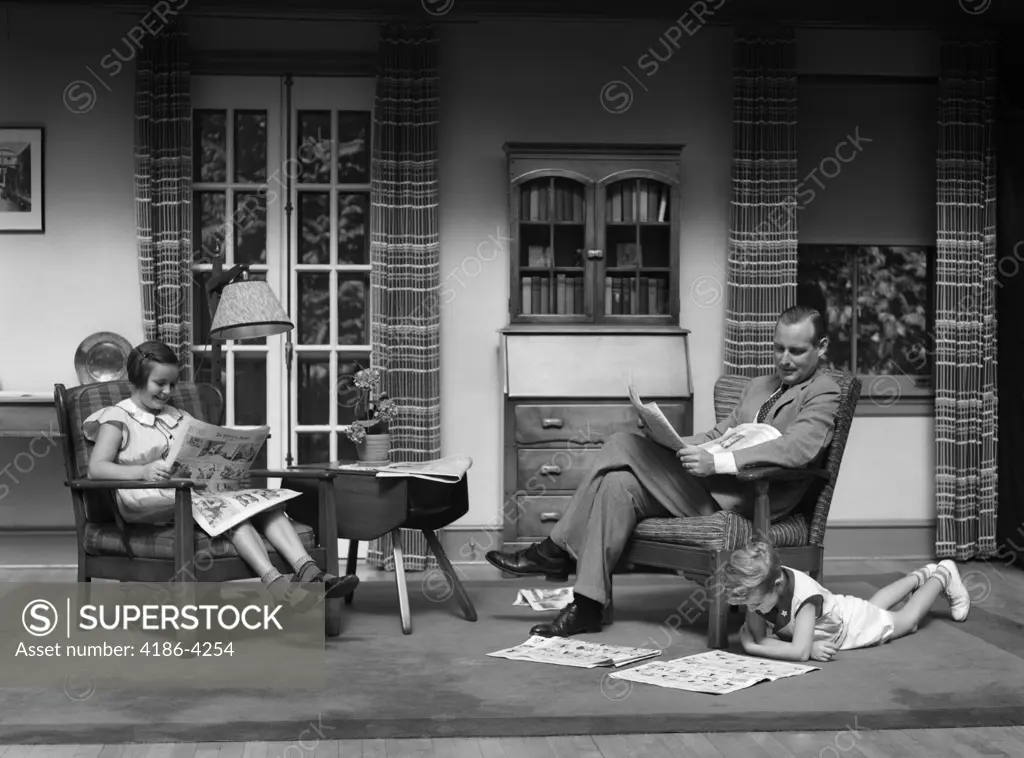 1930S Man Father Reading Newspaper Boy Girl Reading Comics In Living Room