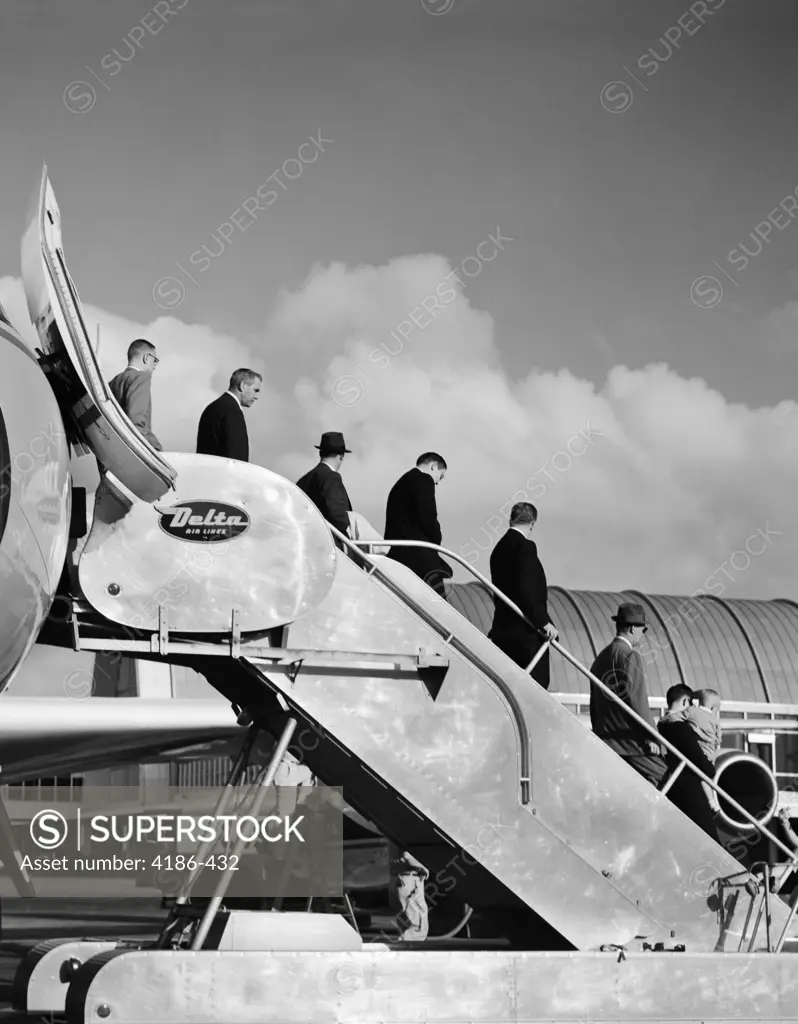 1960S Line Of Businessmen Walking Down Stairway Off Jet Airplane