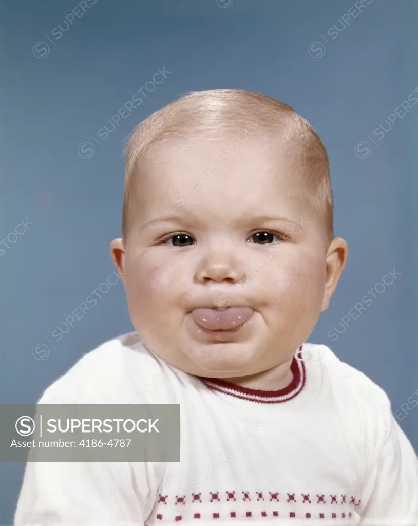 1960S Portrait Of Cute Blond Chubby Baby Looking At Camera Sticking Out Tongue