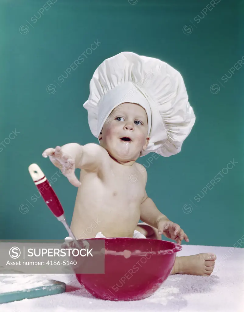 1960S Baby Wearing Chef Hat With Red Mixing Bowl And Spoon Funny Facial Expression