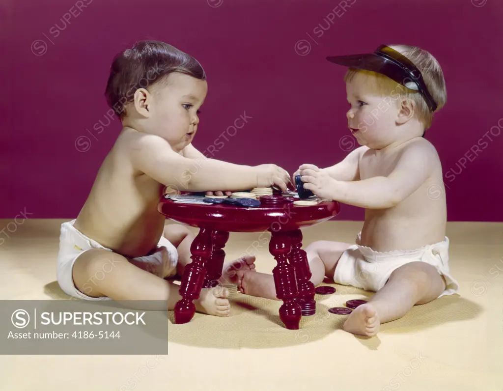 1960S Two Babies Sitting At Red Stool Playing Cards Poker With Gambling Chips