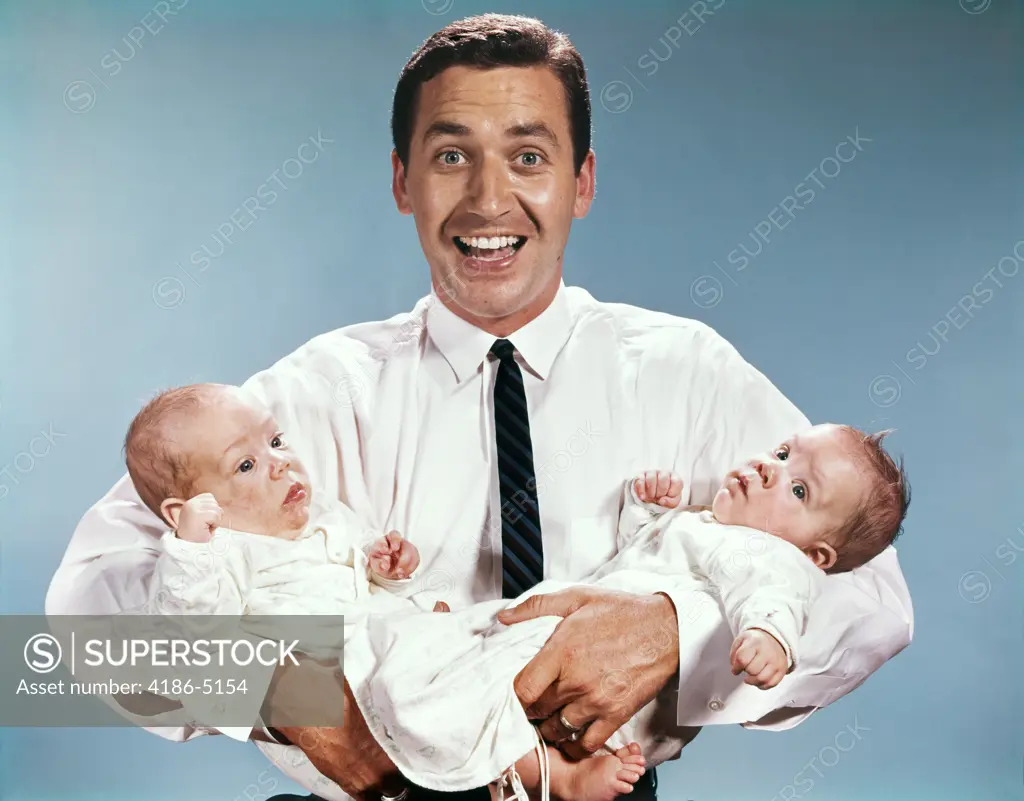 1960S Smiling Man Father Looking At Camera Holding Twin Babies Infants