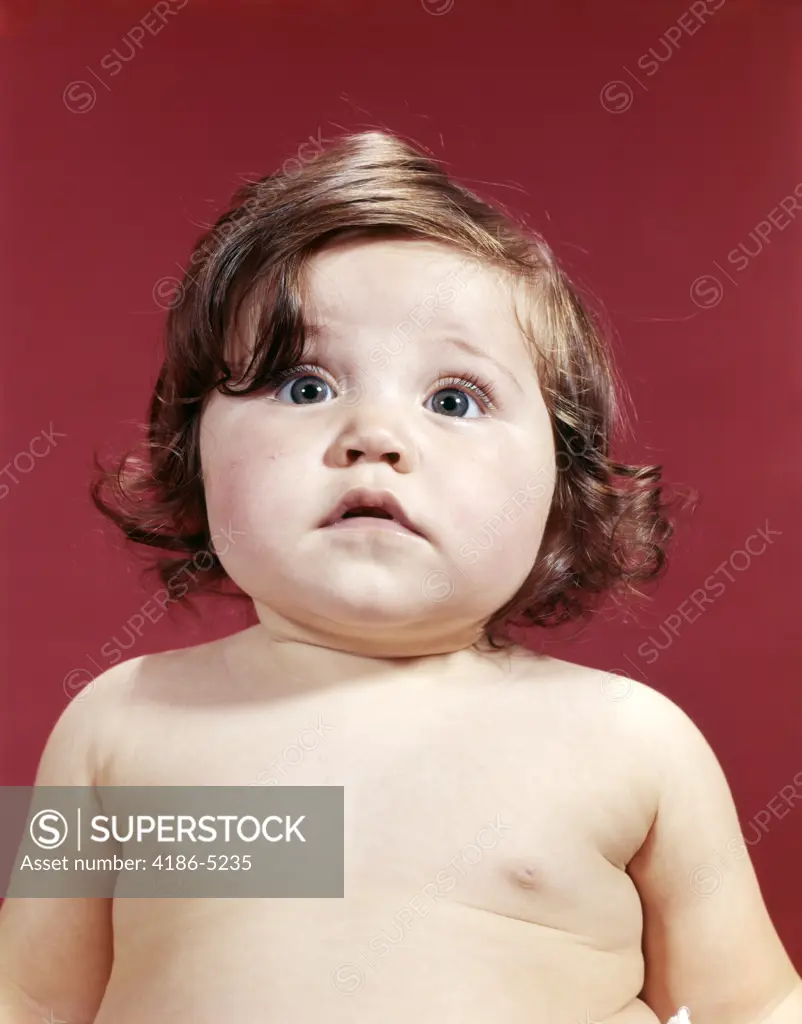 1960S Portrait Brunette Baby Girl With Chubby Round Face Uncertain Facial Expression