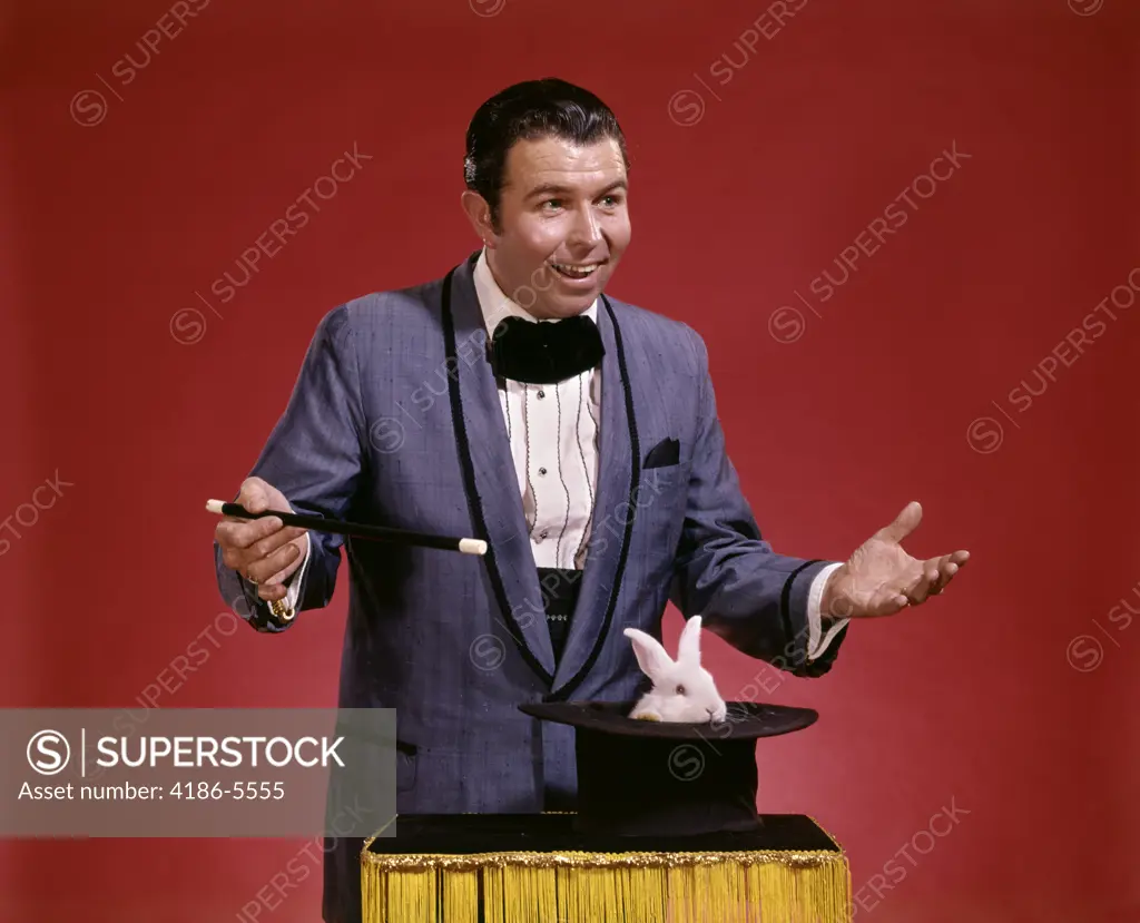 1970S Man Magician Waving Wand Over Top Hat Inverted On Table Flowers Appear Magic