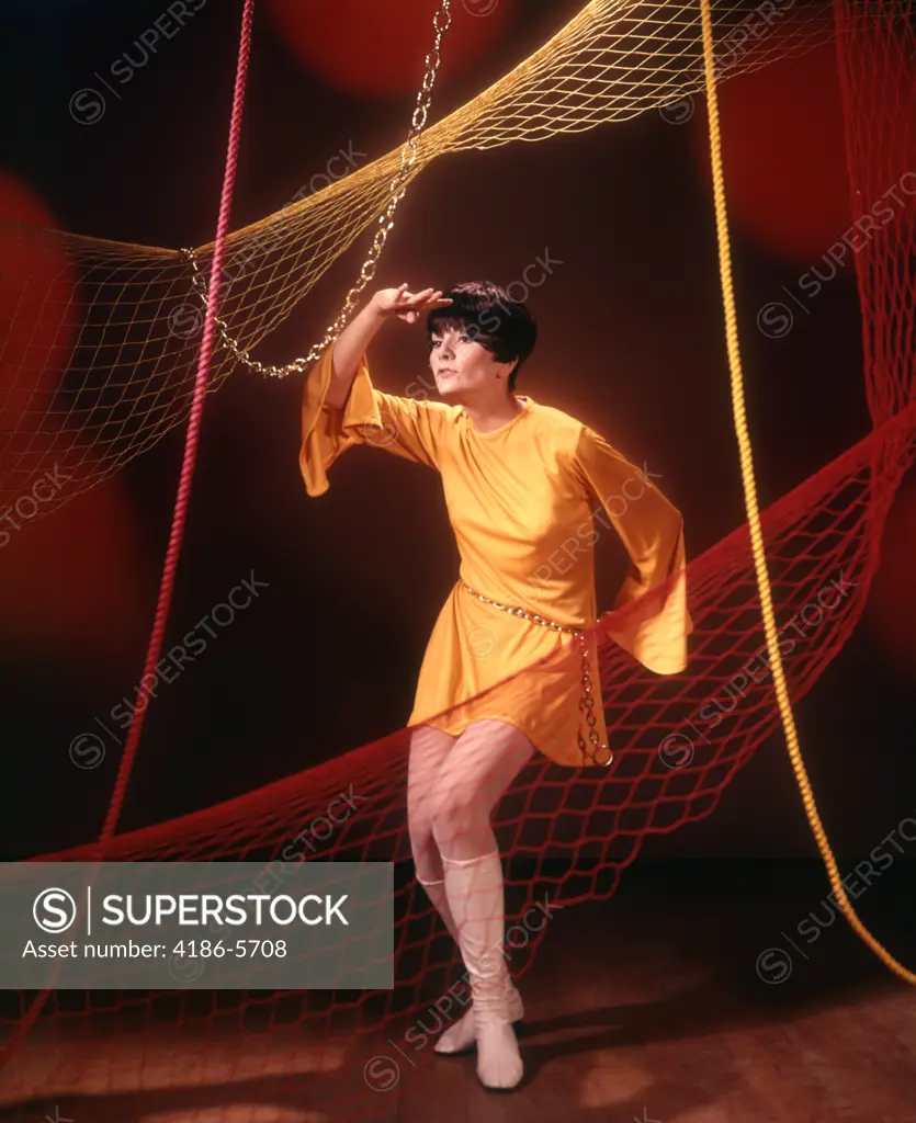 1960S 1970S Young Woman In Short Gold Tunic Dress Dancing Among Nets And Ropes