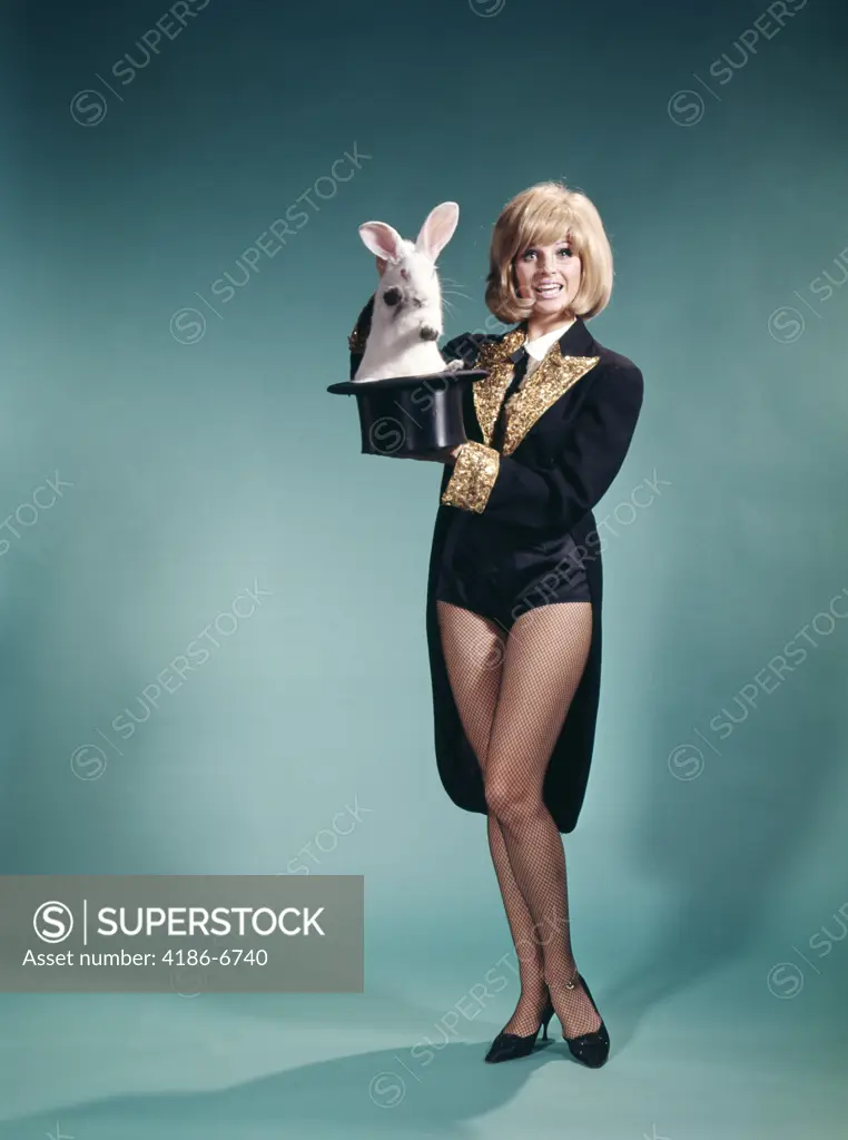 1960S Young Blond Woman In Stage Magician Coat And Short Shorts Pulling Rabbit Out Of Top Hat