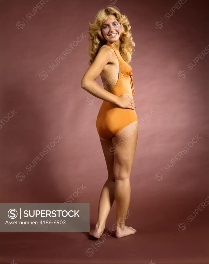 1970S Smiling Woman Wearing Orange Bathing Suit Looking Over Her Shoulder