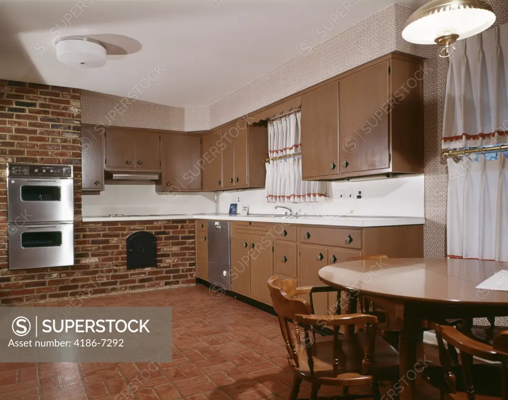 1980S Kitchen With Dark Wooden Cabinets Brick Wall And Stainless Steel Double Oven