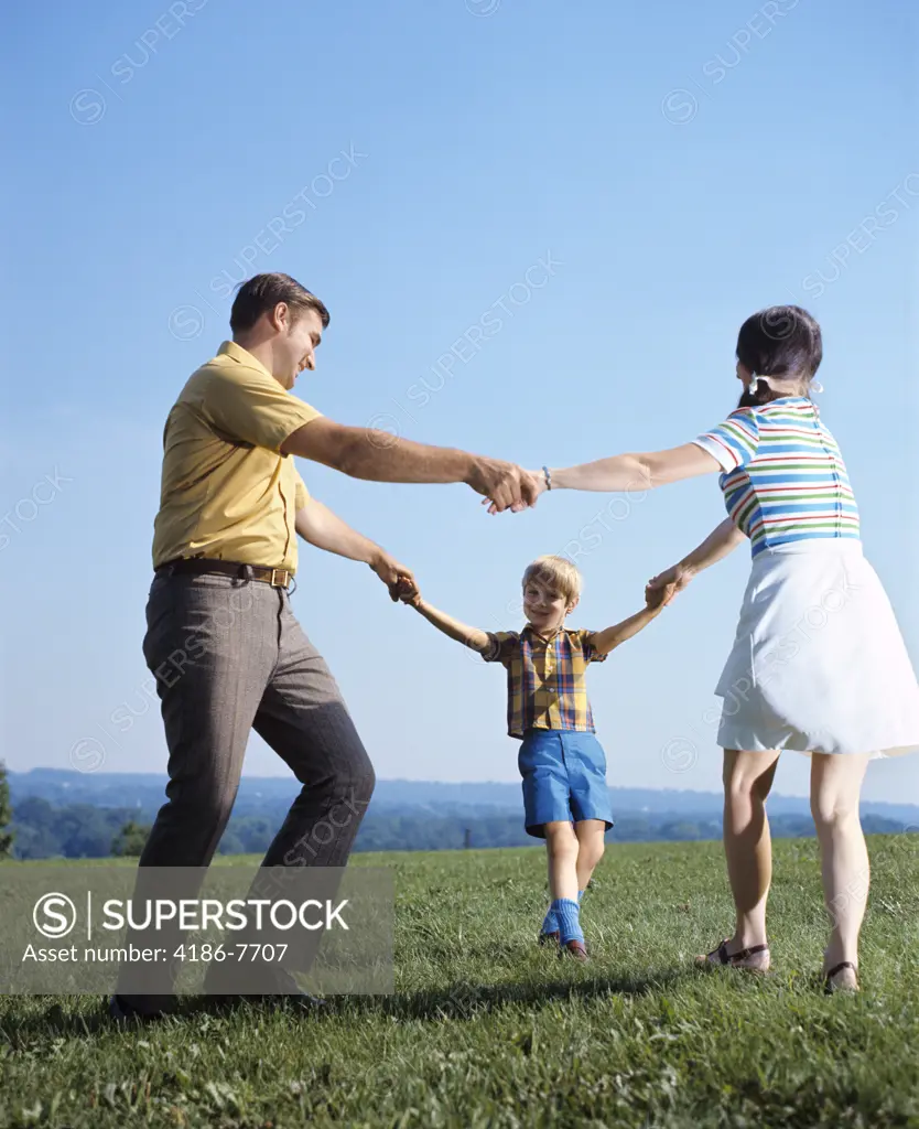 1970S Family Mother Father Boy Playing Ring Around Roses Holding Hands Circle Man Woman Child