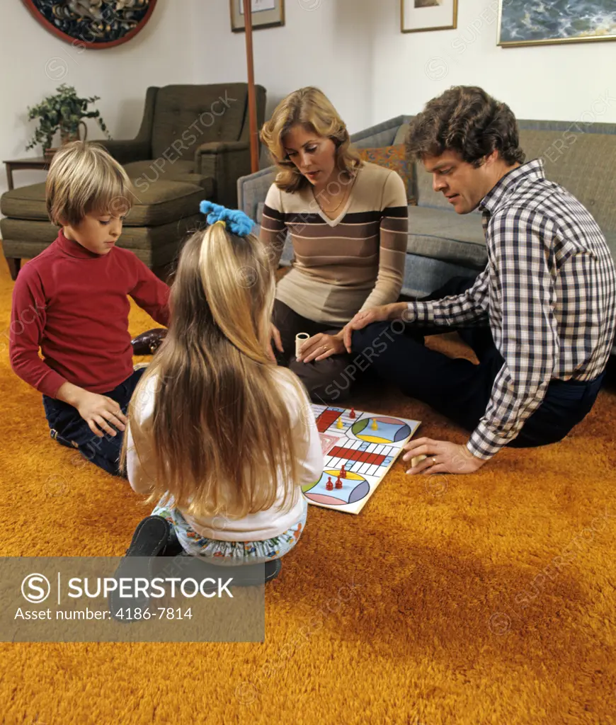 1970S Family Playing Parcheesi On Living Room Floor With Bright Orange Shag Carpeting