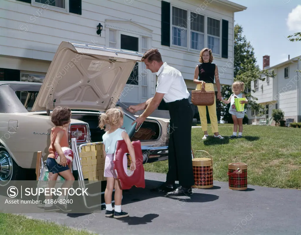 1960S Family Mother Father Three Daughters Packing Luggage Into Car For Vacation Outdoor