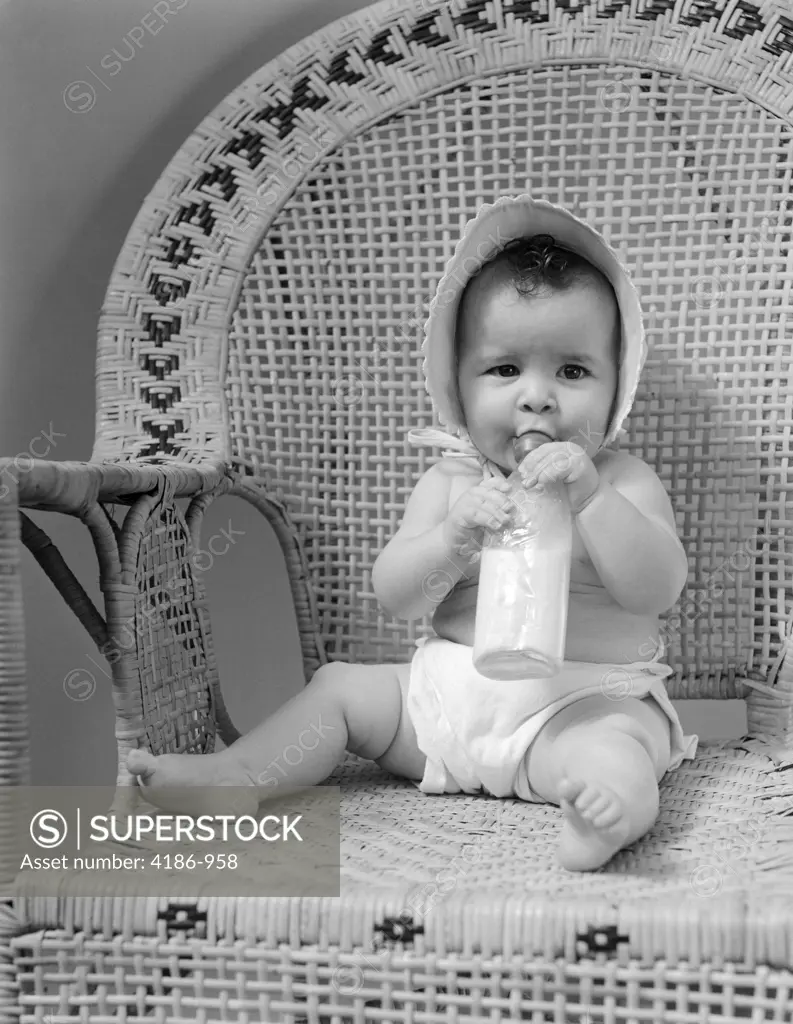 1940S Baby Sitting In Wicker Chair Sucking Milk Bottle