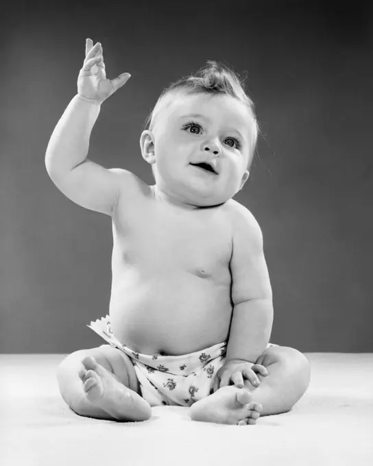 1950S Portrait Of Baby Sitting One Arm Raised Indoor