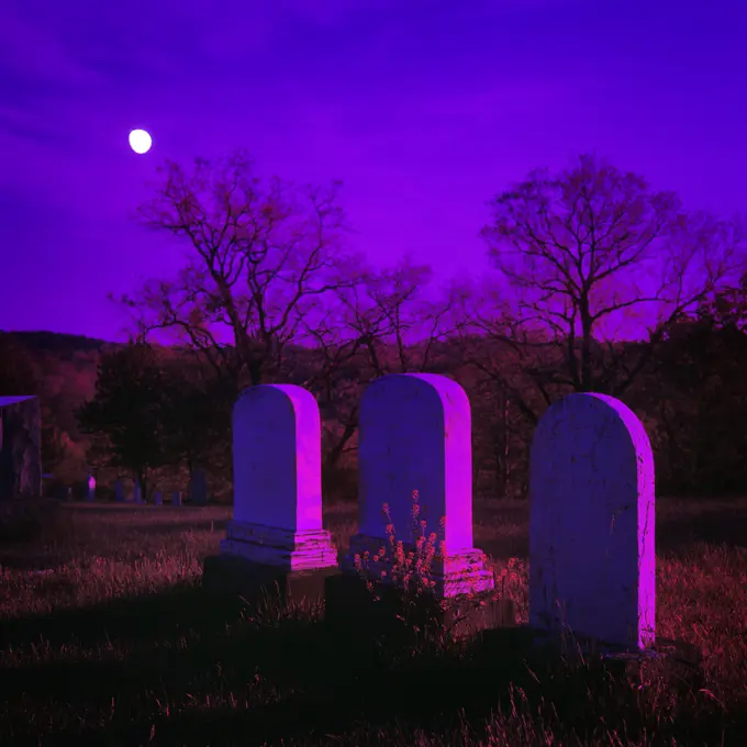 1980s THREE TOMBSTONES IN DARK CEMETERY UNDER BRIGHT MOON WITH PURPLE FILTER GRAPHIC EFFECT