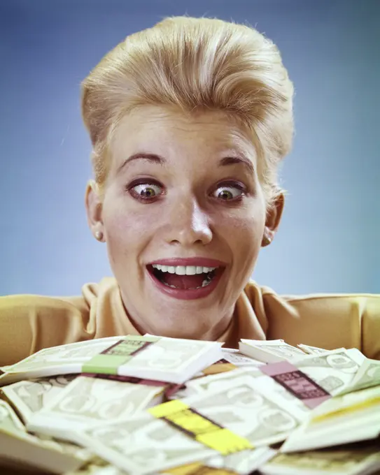 1980s SURPRISED AMAZED  BUG-EYED BLONDE WOMAN LOOKING AT PILE OF CASH MONEY