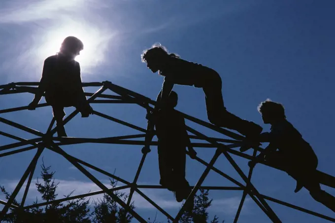 1980s FOUR ANONYMOUS SILHOUETTED KIDS CLIMBING ON GEODESIC JUNGLE GYM