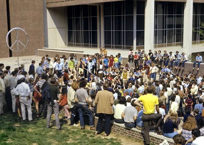 1960s 1970s GROUP OF ANTI-WAR STUDENT PROTESTERS GATHERING DEMONSTRATING NEAR PEACE SIGN