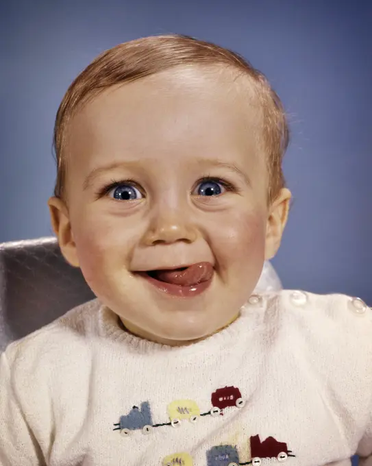 1960s HAPPY BABY BOY MAKING A FUNNY FACE LICKING HIS LIPS WITH HIS TONGUE