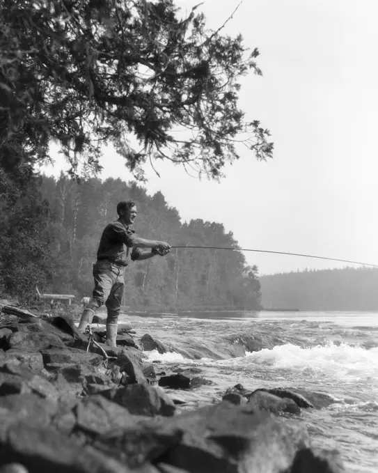 1920s MAN SPORTSMAN CASTING FLY FISHING IN WILDERNESS STREAM BRITISH COLUMBIA CANADA