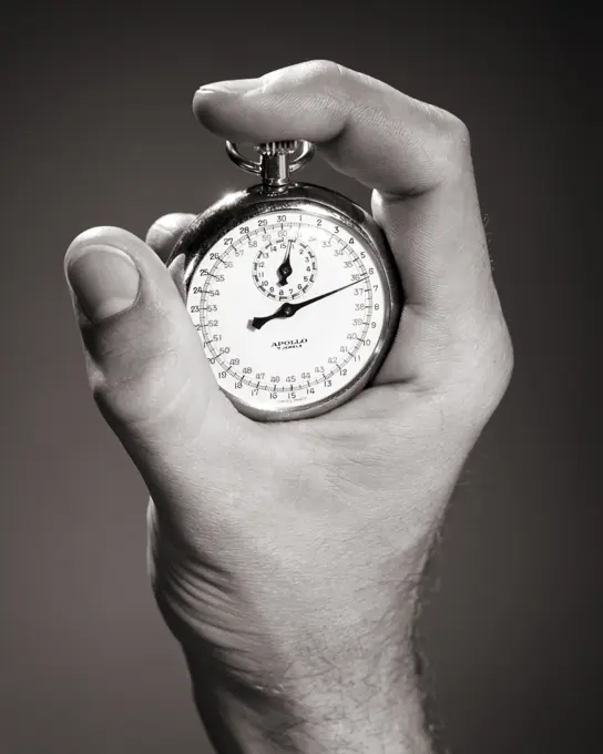 1960s MALE HAND HOLDING A STOPWATCH