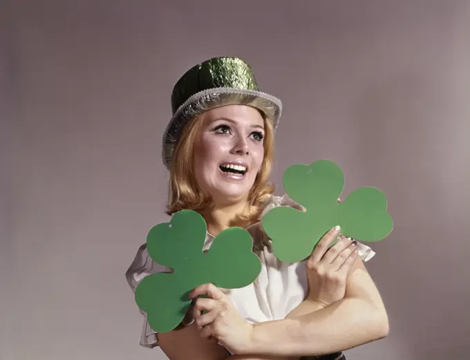 1960S Woman Smiling Holding Green Shamrocks Wearing Green Party Hat For Saint Patrick'S Day