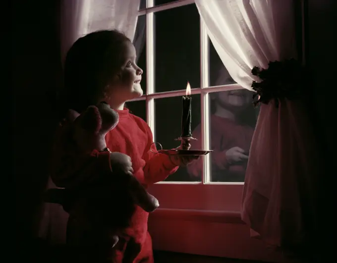 1950S Little Girl Red Pajamas Stuffed Animal Under Arm Hold Burning Candle By Window Night Christmas Eve