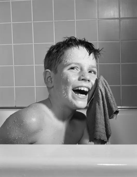 1950S 1960S Smiling Boy Washing Face Sitting In Bathtub