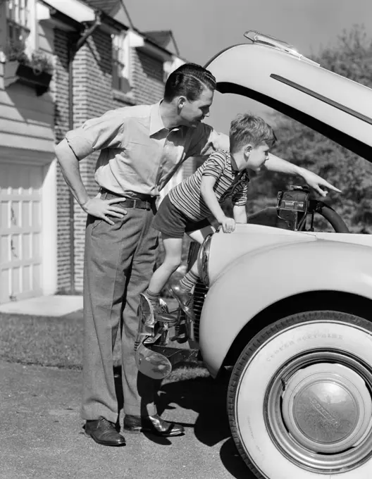 1940S Father & Son Checking Under Hood Of Car In Driveway