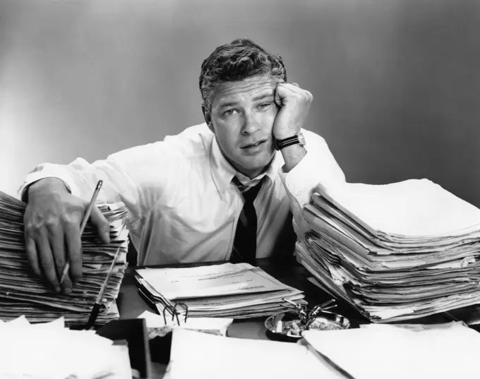 1950S Portrait Man Overworked With Desk Full Of Papers