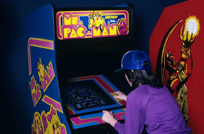 1980S Teen Girl Wear Baseball Cap Playing Ms Pac Man Video Game In Arcade