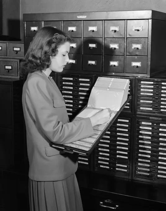 1940S 1950S Woman In Office Standing Near Filing Cabinets