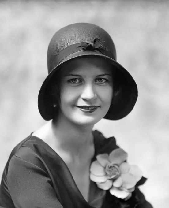 1930S Head & Shoulders Portrait Of Smiling Woman Wearing Hat & Flower On Blouse