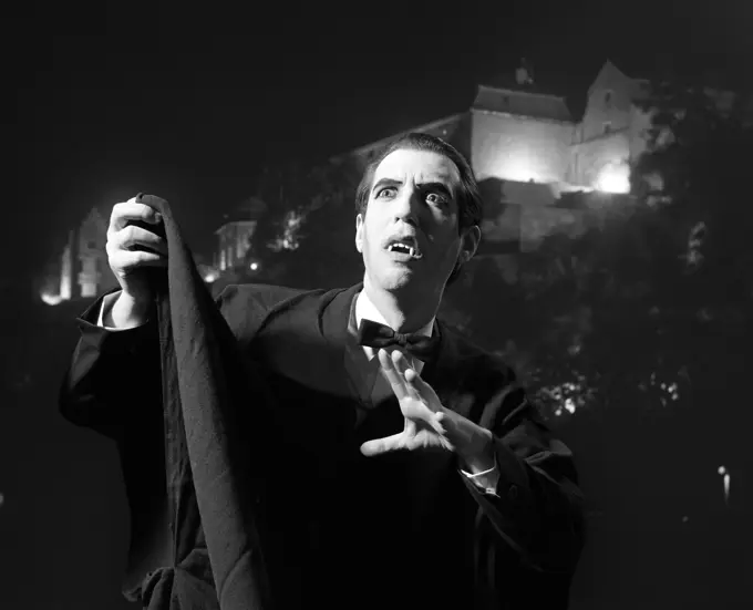 Nighttime Portrait Of Man Wearing Cape And Fangs Dressed As Dracula