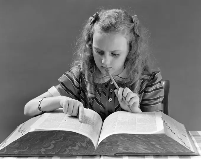 1940S Young Girl Looking In Dictionary Holding Pencil To Chin