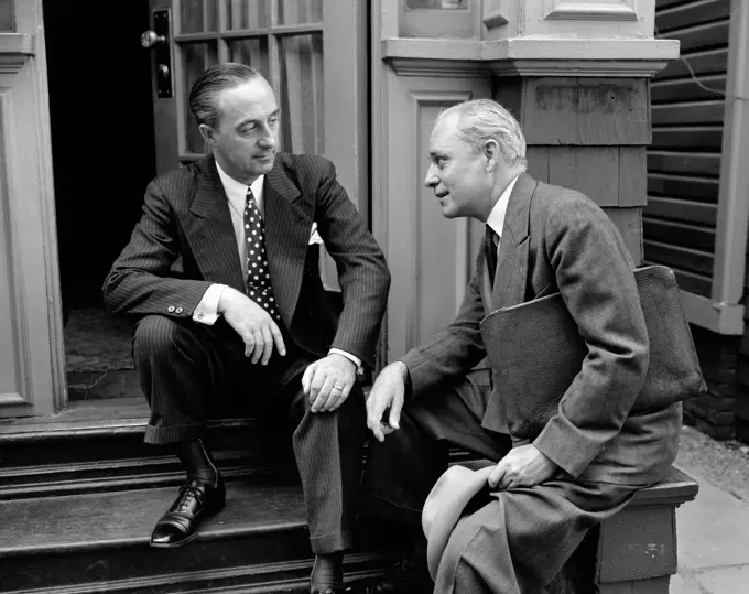 1930S 1940S Salesman And Home Owner Man Sitting Together On Front Stoop Talking Sales Presentation