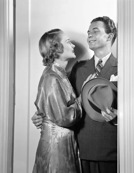 1940S Couple In Doorway Embracing Man In Suit Holding Hat Woman In Satin Print Gown